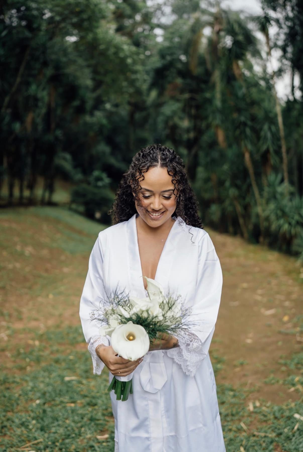 Noiva de robe segurando o buquê no jardim da Fazenda
